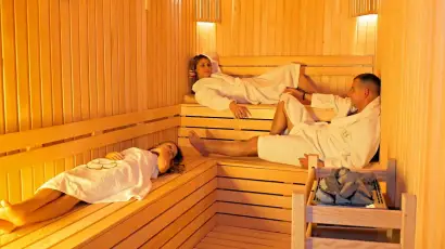 Guests in bathrobes in a wood-panelled Finnish sauna at Therabliss Spa, Konyaalti Antalya